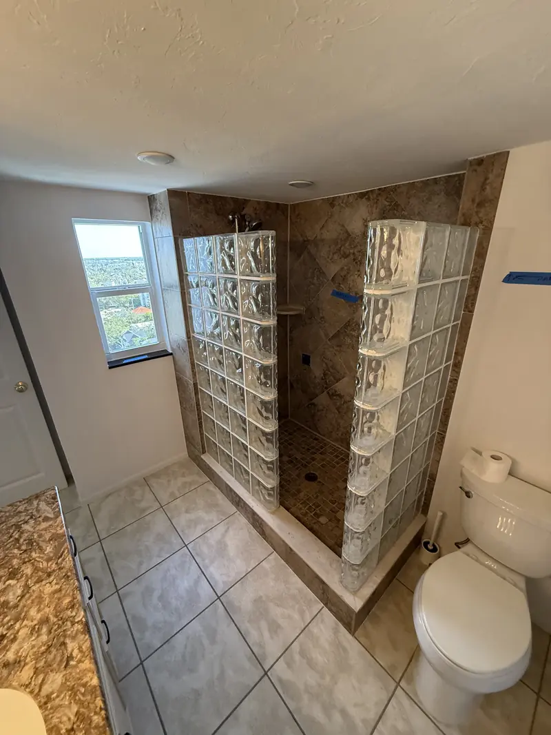 Before: Old glass block shower with brown tile before the bathroom remodel in Sarasota, FL
