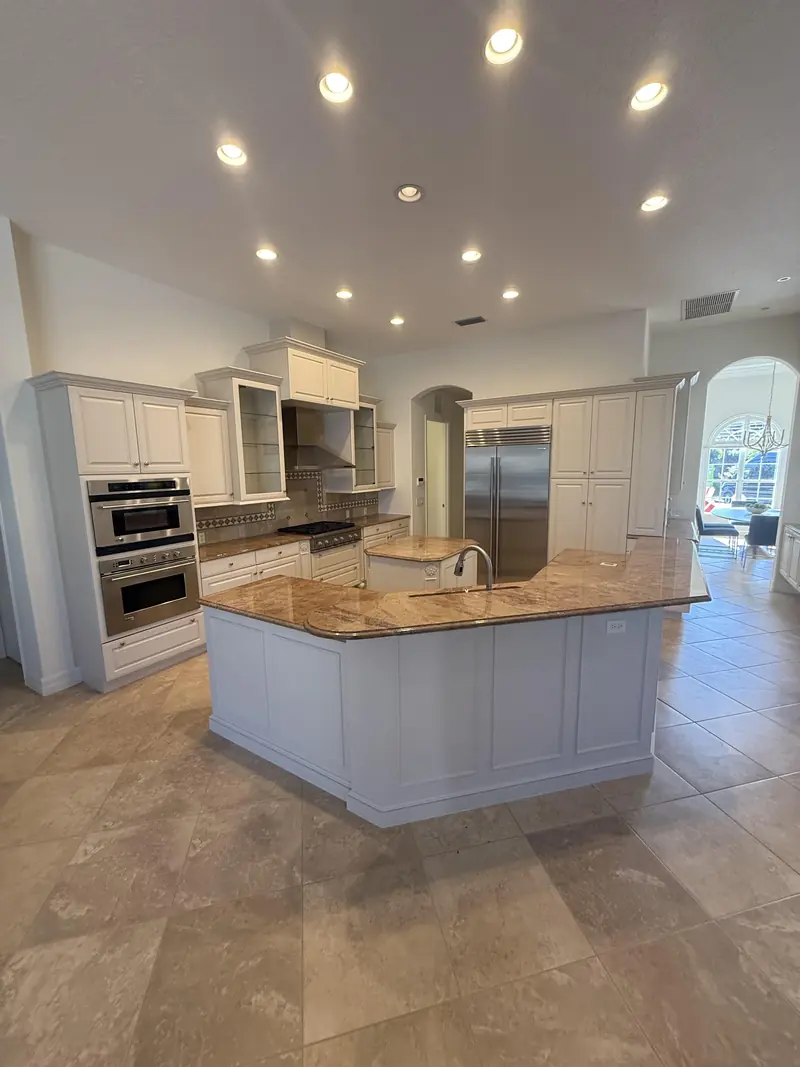 Before: Original kitchen with raised-panel cabinets and granite island before renovation in Lakewood Ranch