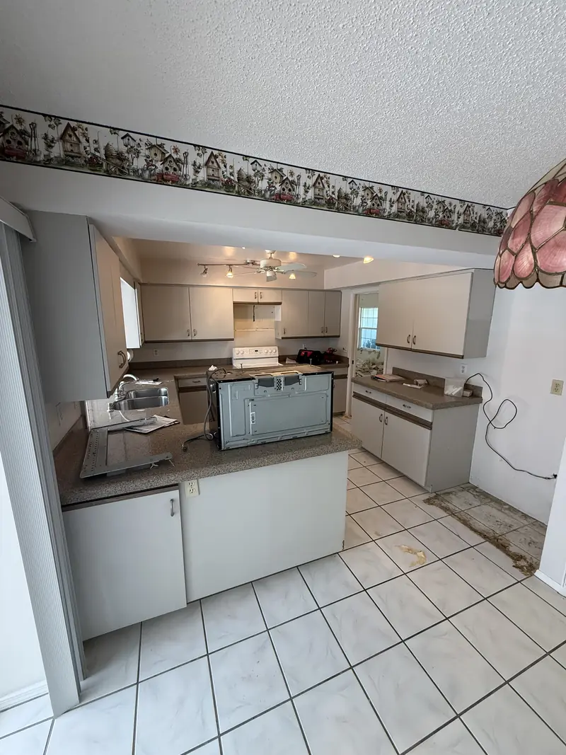 Before: Dated kitchen with wallpaper border and tile floor before remodeling in Osprey